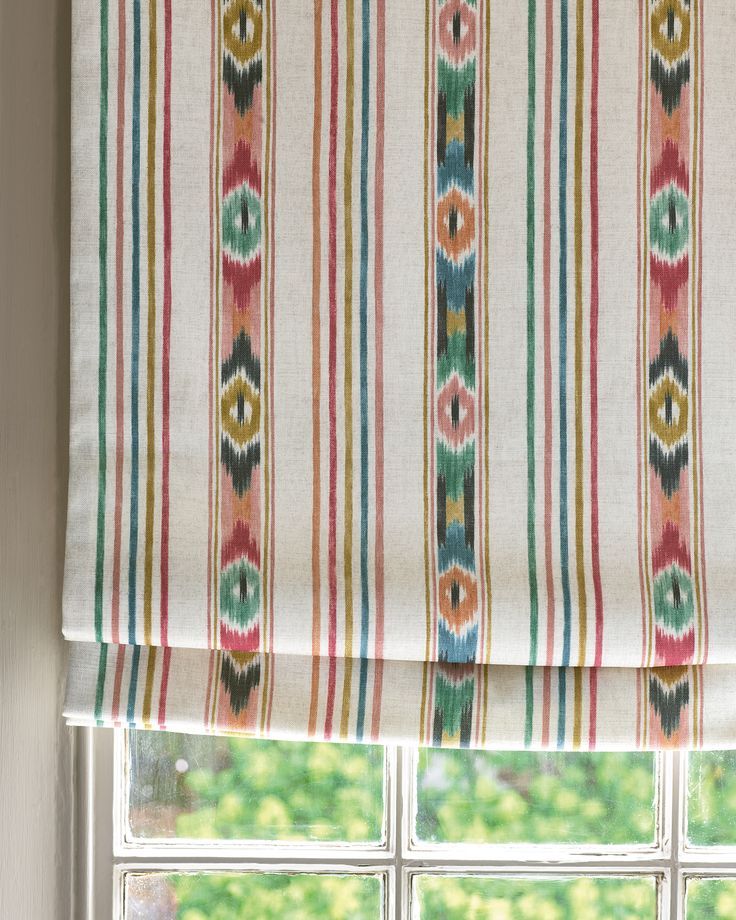 a window with a striped roman blind in front of it