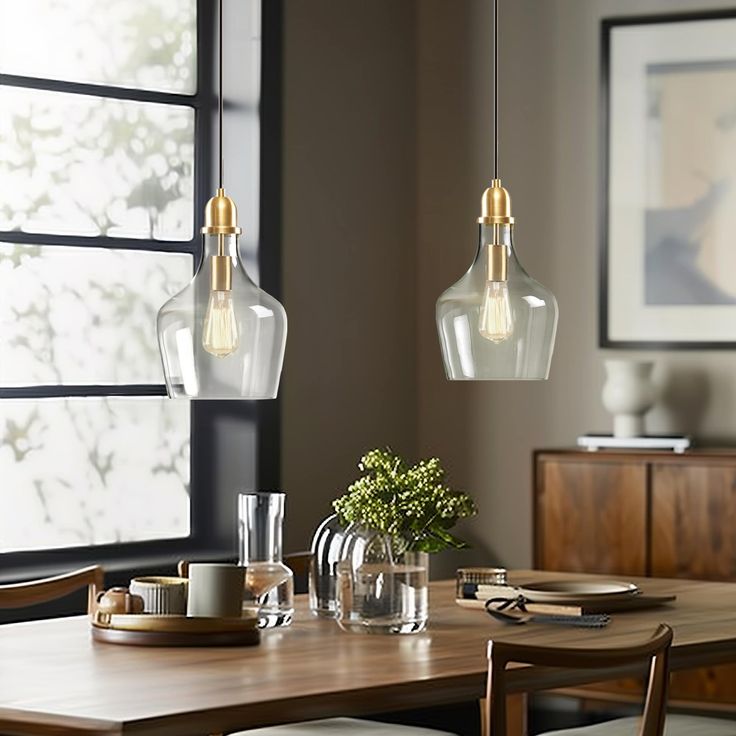 a dining room table with two hanging lights above it