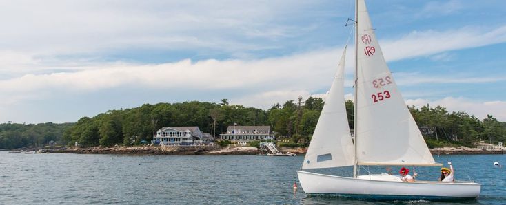 a sailboat with two people on it in the water