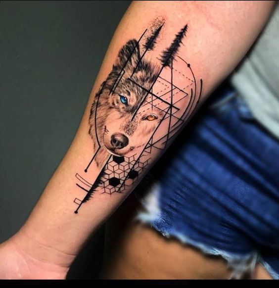 a woman's arm with a wolf and geometric tattoo design on the left forearm