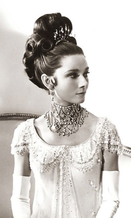 a woman in a white dress wearing a necklace and gloves