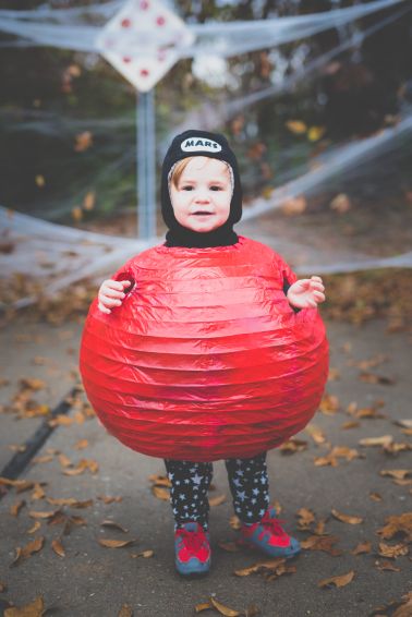 a young child is holding a large red ball