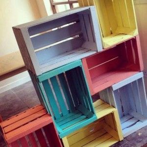 colorful wooden crates stacked on top of each other in a room with tile flooring