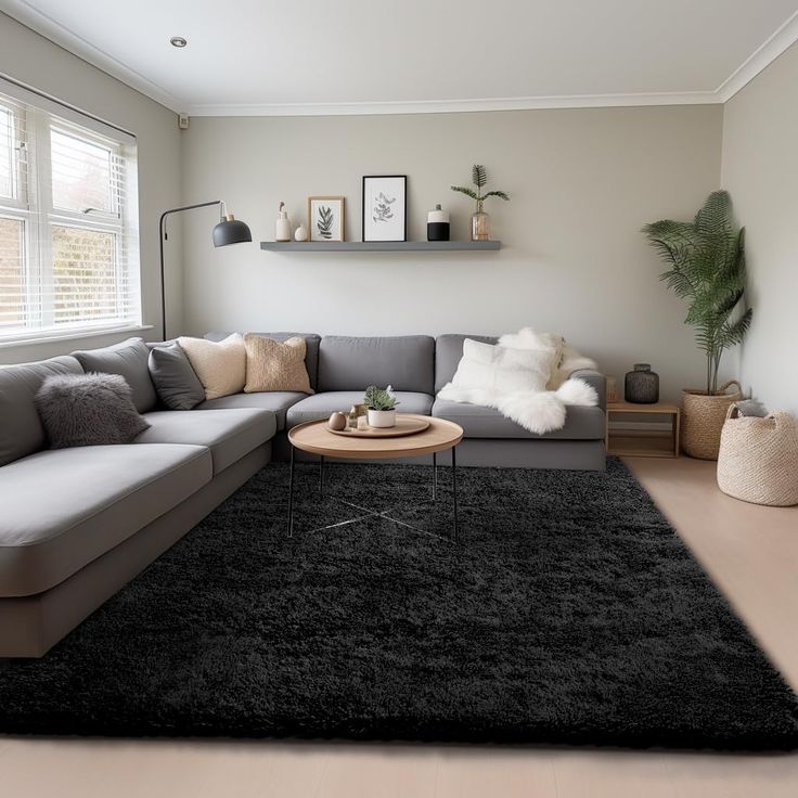 a living room filled with furniture and a large rug on top of a floor next to a window