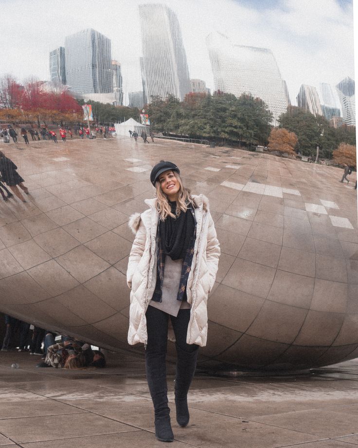 a woman standing in front of a giant mirror ball with her hands on her hips