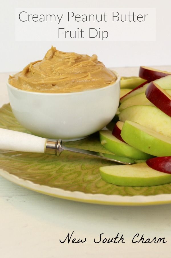 a bowl of peanut butter and apples on a plate