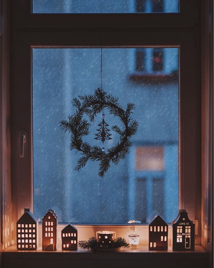 a window sill with christmas decorations on it and a wreath hanging from the window