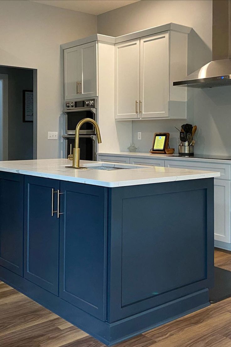 a kitchen with an island in the middle of it and white cabinets on both sides