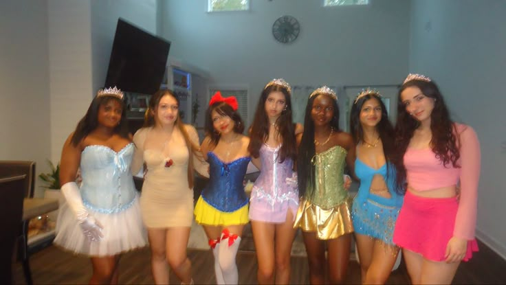 a group of women dressed in costumes posing for a photo with one woman wearing a tiara