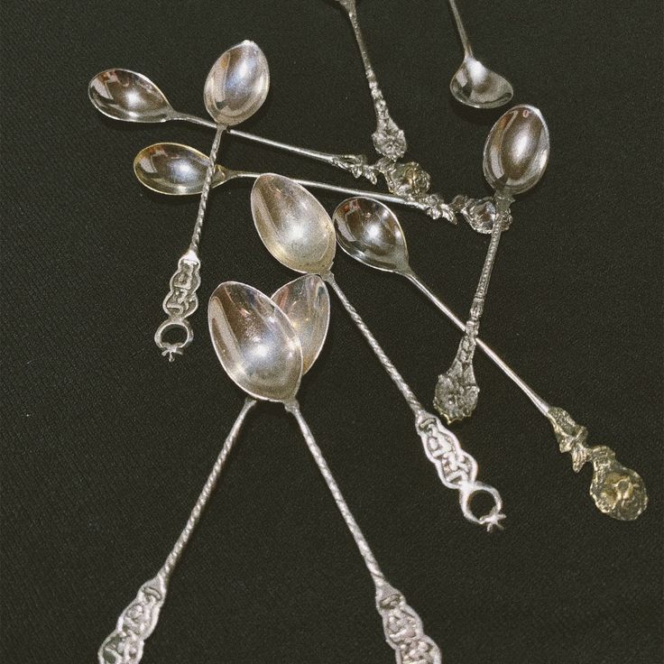 several spoons are arranged on a black surface