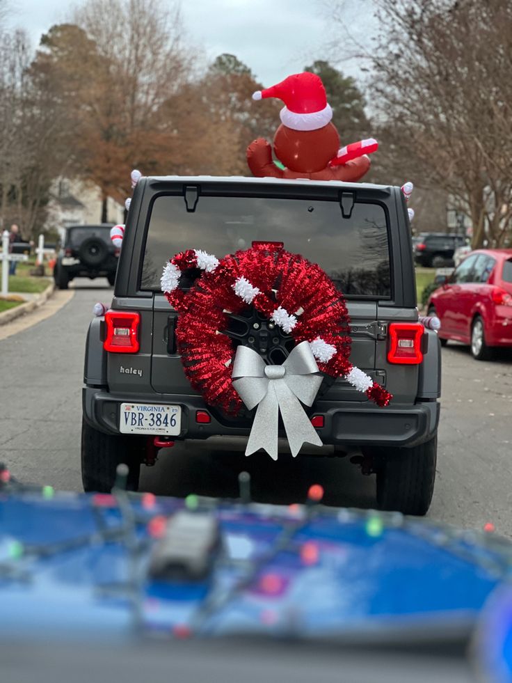 a jeep with a wreath and santa hat on the back