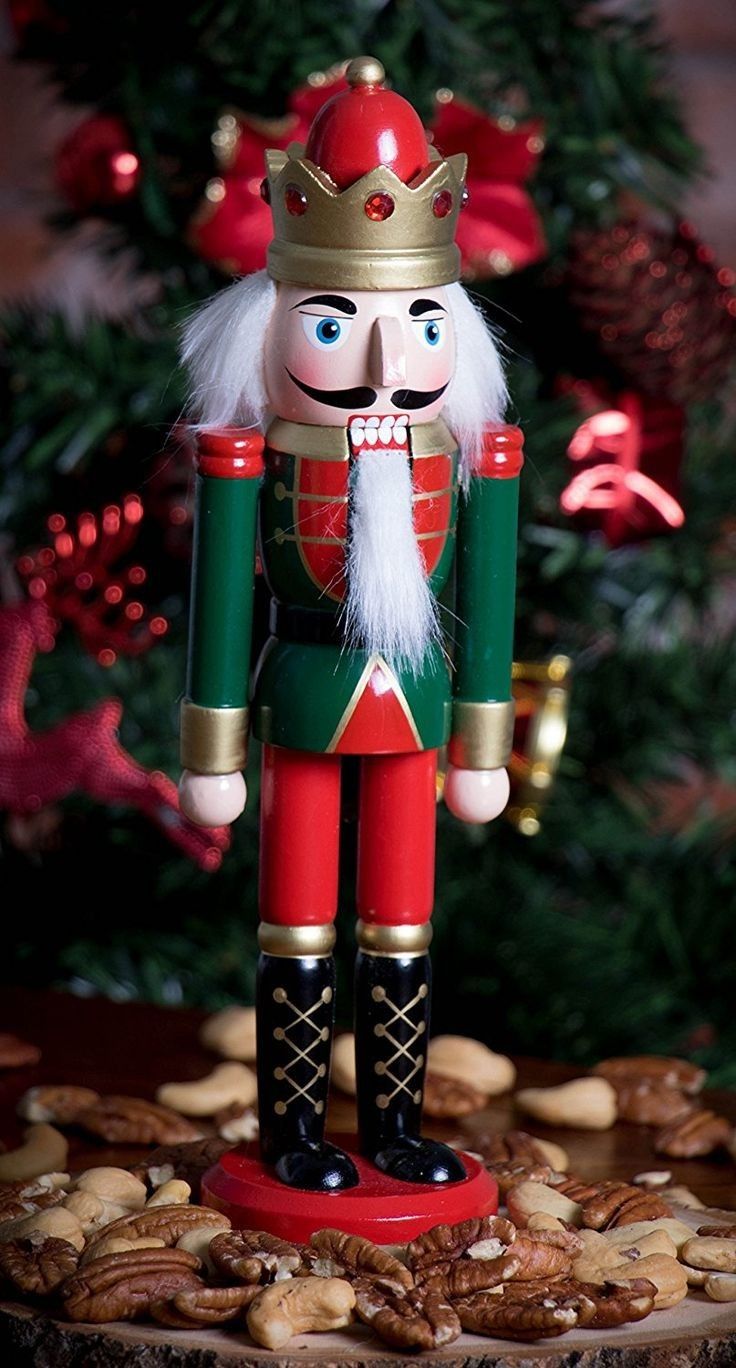 a nutcracker is standing in front of a christmas tree