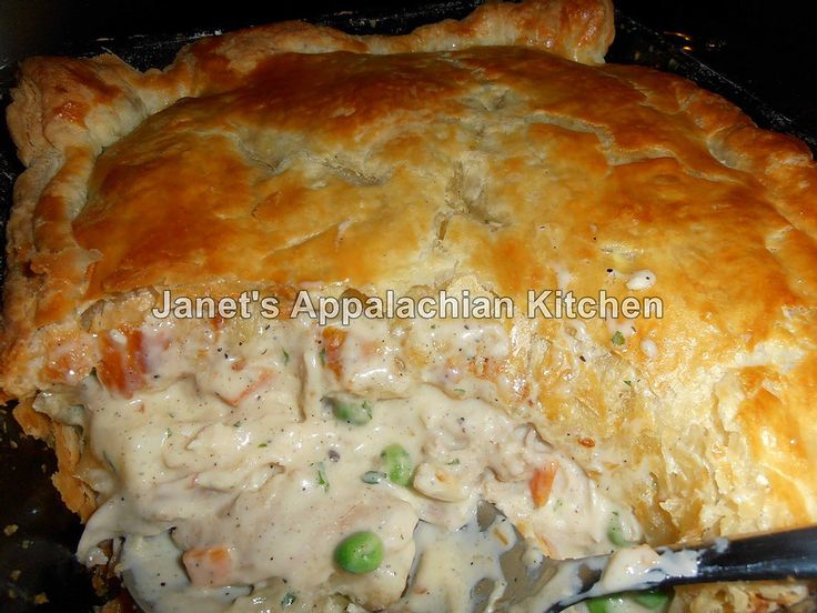 a chicken pot pie is being eaten with a knife and fork from the casserole