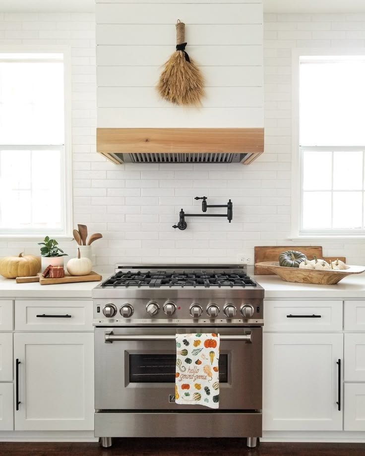 a stove top oven sitting inside of a kitchen next to white cabinets and counter tops