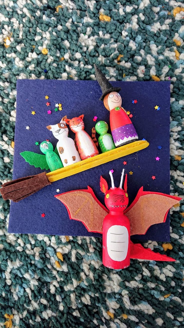 a craft project with toothpicks, pencils and paper dolls on top of it