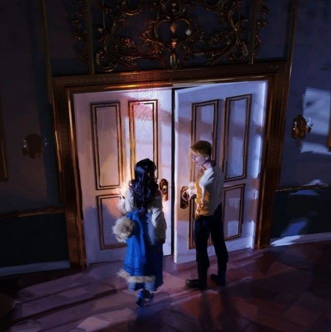 two children are standing in front of an open door