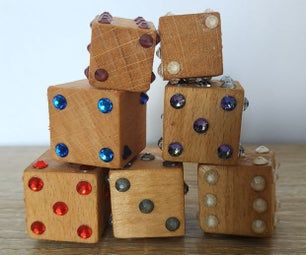 several wooden dices stacked on top of each other with colored jewels around them, sitting on a table