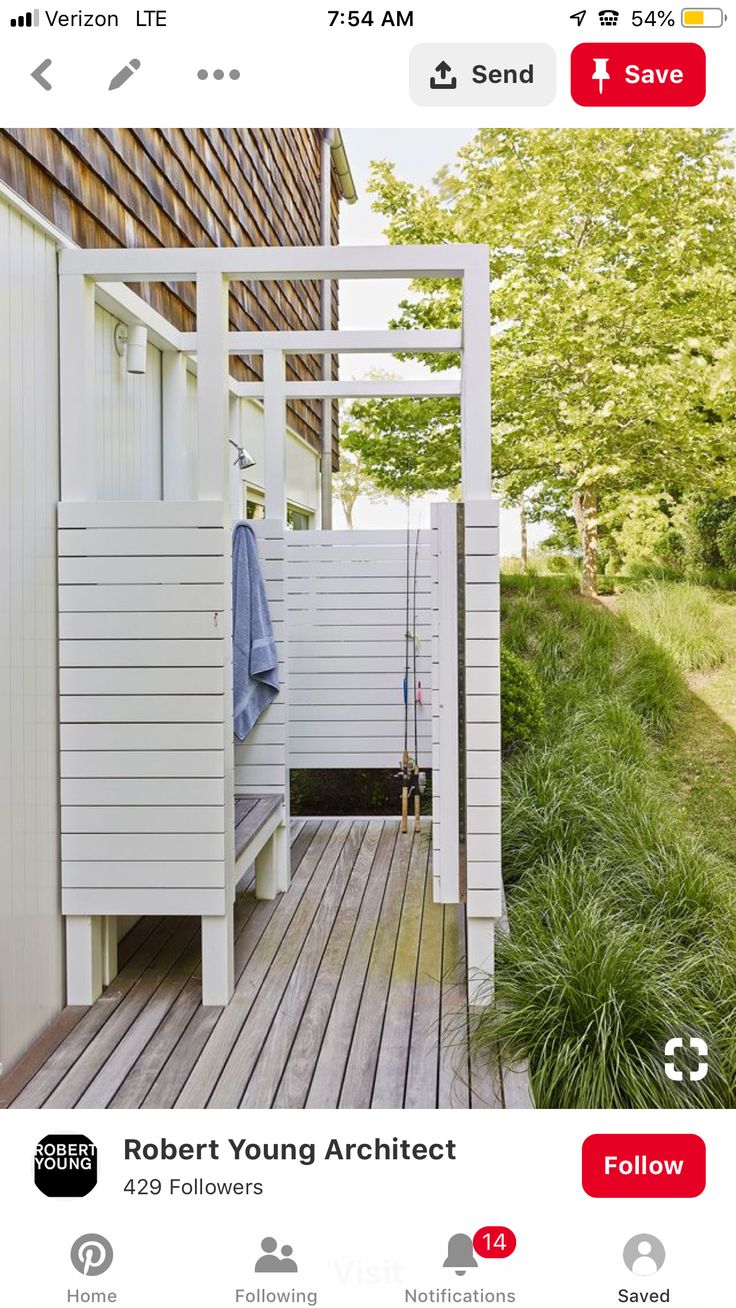 there is a white bench on the deck next to a building with a blue towel hanging from it