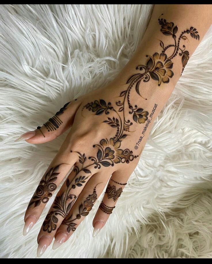 a woman's hand with henna tattoos on it