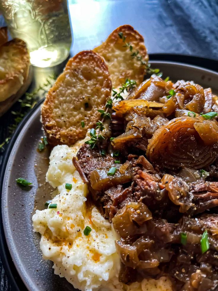 a plate with potatoes, meat and gravy on it