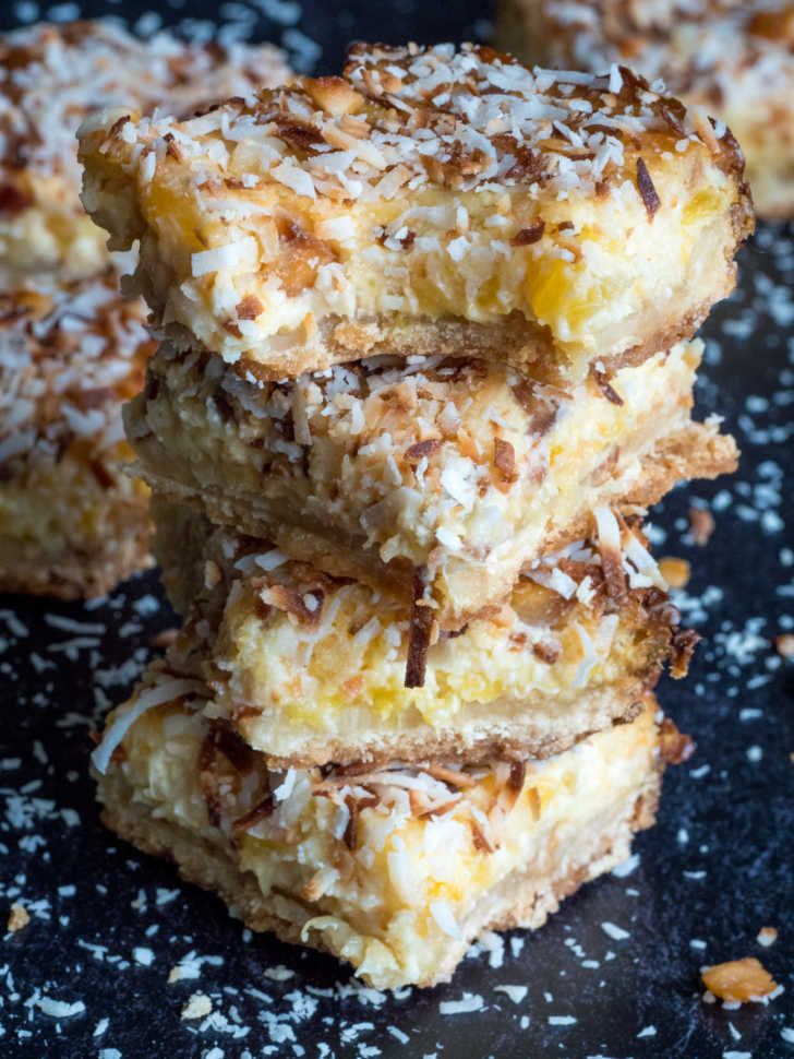 three pieces of dessert are stacked on top of each other with coconut flakes all over them