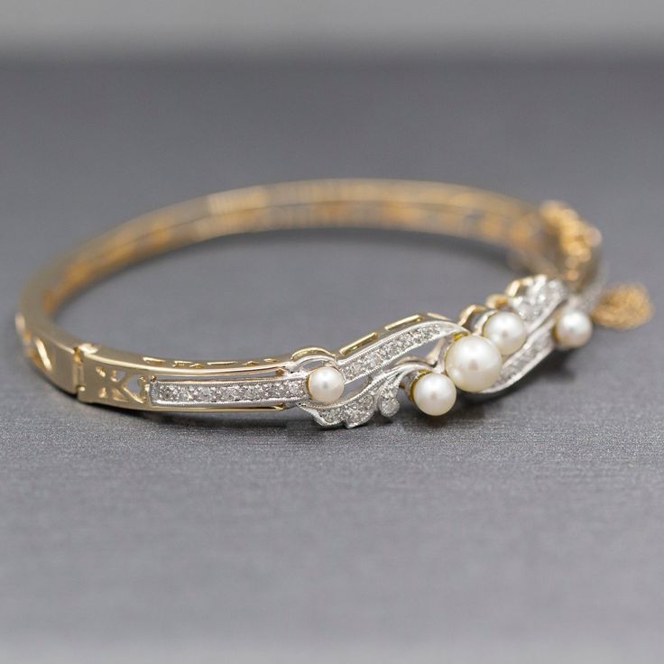 This stunning bracelet is a perfect period piece in exquisite condition. The bracelet features a bangle design with a hinged opening at the side. The top of the bracelet is encrusted with diamonds and pearls. The pearls and cultured and measure 6.14mm (largest and 3.84 (smallest). The design features single cut round diamonds, thirty two of them. The stones are VS/SI clarity and are G/H color. They measure 1.5mm each for a total weight of 0.48cttw. The piece is constructed in solid 14k yellow go Bangle Design, Period Piece, Diamond Bangles, Diamond Bangle Bracelet, Diamonds And Pearls, Thirty Two, Diamond Bangles Bracelet, Bangle Designs, Diamond Bangle