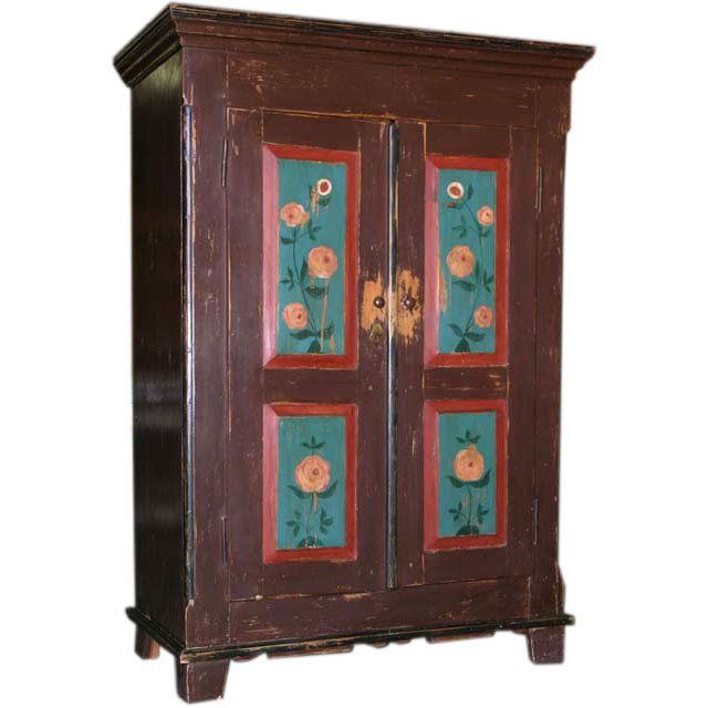 an old wooden cabinet with flowers painted on the front and sides, sitting against a white background