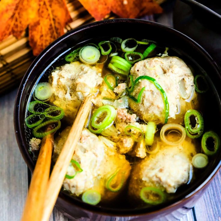 a bowl filled with meat and vegetables next to chopsticks