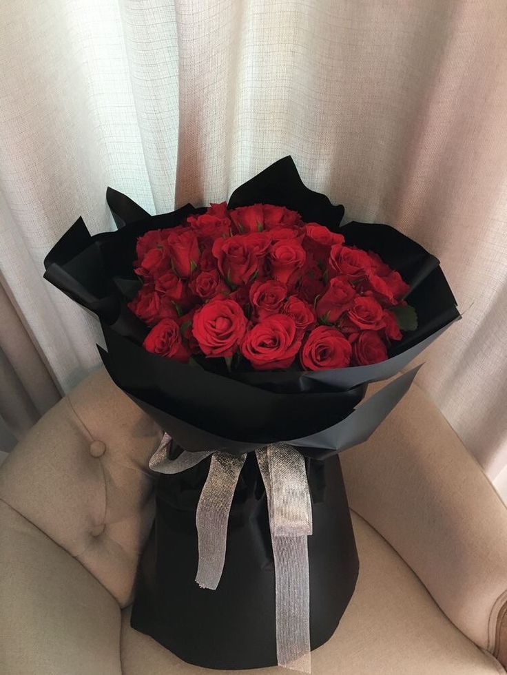 a bouquet of red roses sitting on top of a chair