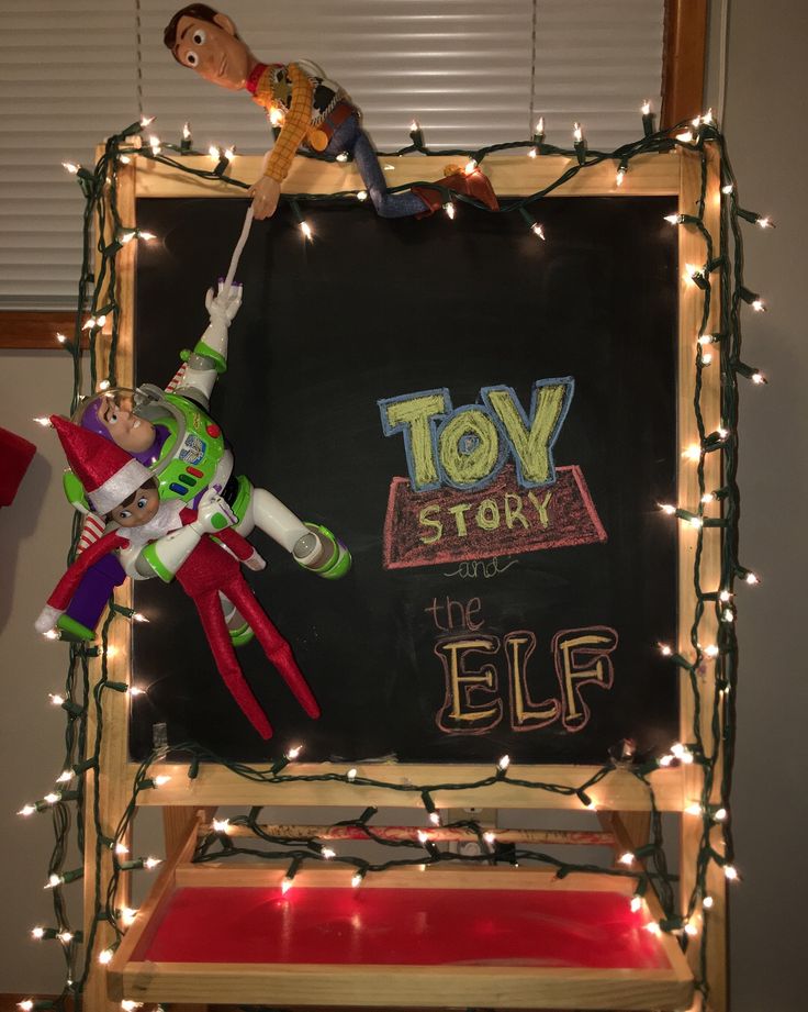 an elf is hanging on the back of a toy story sign