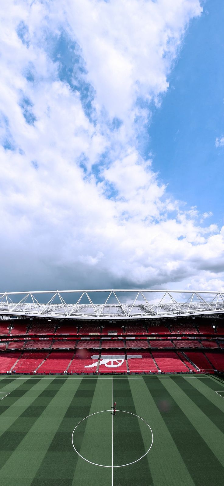 an empty soccer field with the sky in the background