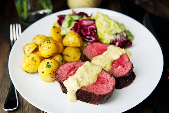 a white plate topped with steak and potatoes