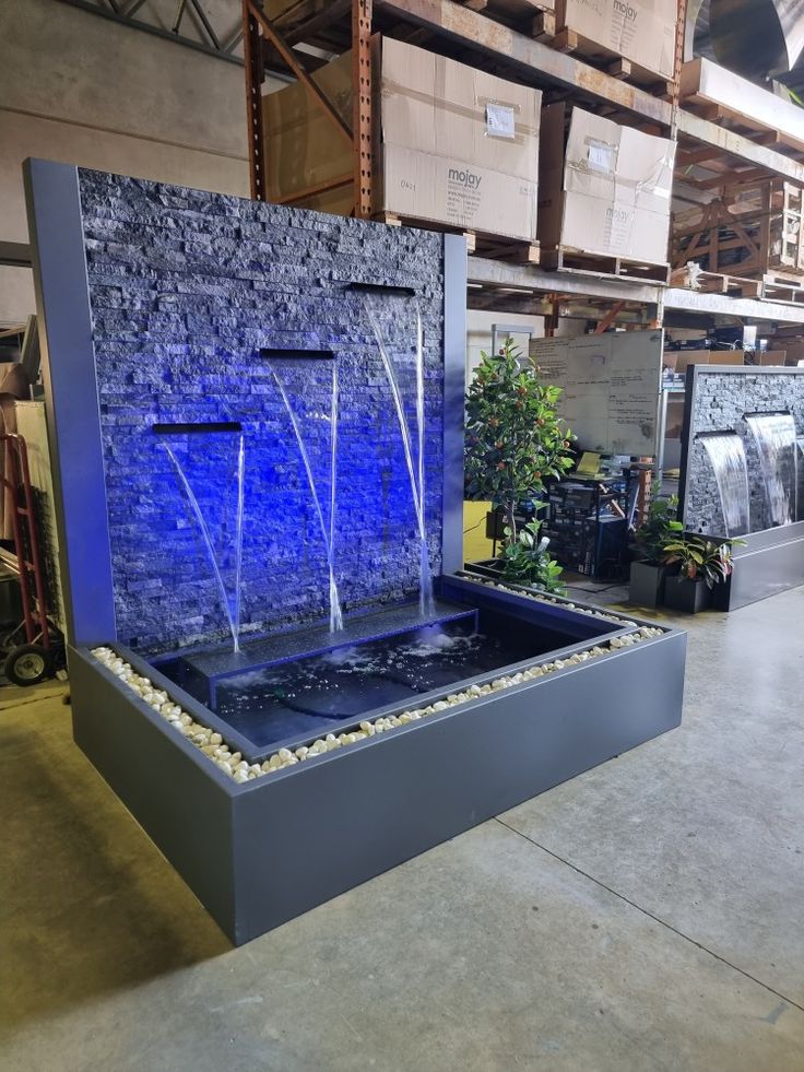 an indoor fountain with blue water running down it