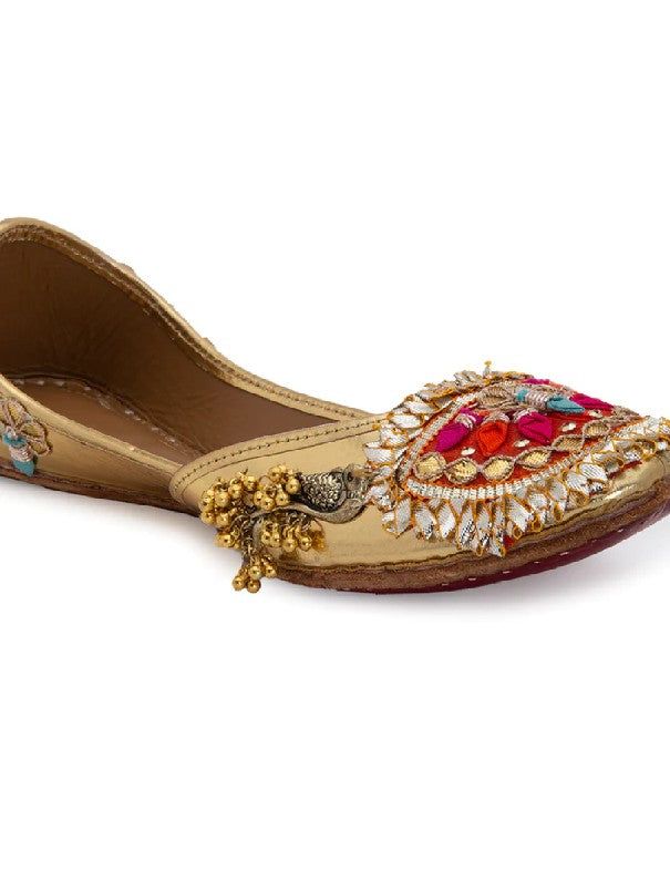 Gold juttis with intricate Goota work in vibrant colours tans peacock ghungroo embellishment and assure love at first sight! Double Cushioning for Extra Comfort Color: Gold and Orange Fabric: Upper: Leahrette Insole - Leather Sole - Vegetable tanned Leather Sole Note: Available in other colors The product will be shipped within 20-25 days of the order placed Any slight irregularities are distinctive and are inherent to the beauty of this creation as it is precisely crafted by hands. Care intruct Festive Multicolor Embellished Traditional Wear, Festive Party Flats With Mirror Work, Party Flats With Mirror Work For Festivals, Festive Flats For Navratri, Festive Navratri Flats With Zari Work, Handwork Flats For Festivals, Festive Flats With Dori Work For Navratri, Handwork Flats For Festive Occasions, Handwork Flats For Festive Occasions And Festivals