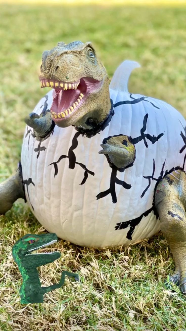 a paper pumpkin shaped like a dinosaur laying on the ground