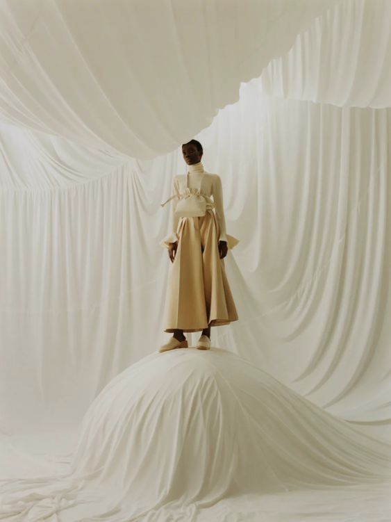 a woman standing on top of a white sheet