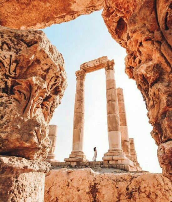 a person standing in between two stone pillars