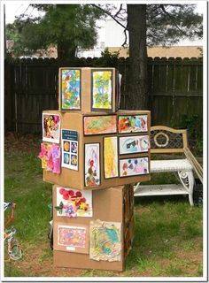 a cardboard box with pictures on it sitting in the grass next to a park bench