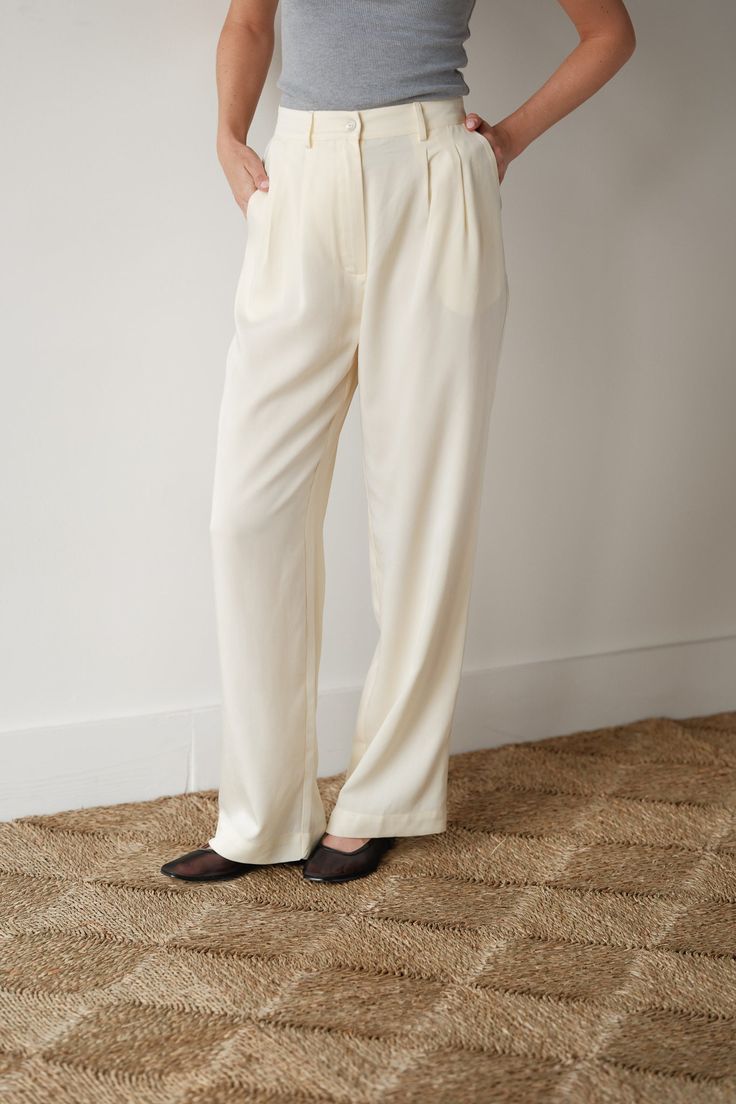 drawing inspiration from traditional suiting with a twist, our pleated trouser is one of our favorite classic go-to styles - ready to take you anywhere feeling polished and comfortable. plus, it's made from cellulose fibers so it's better for the planet. features: mother of pearl button belt loops pockets + pleats twill woven texture made in la pairs perfectly with the crop vest about the fabric: our twill fabric is a soft woven crafted from lyocell fibers derived from cellulose wood pulp, which Chic Cream Bottoms With Pressed Crease, Cream Straight Hem Bottoms For Work, Cream Workwear Pants With Pressed Crease, Classic Cream Wide Leg Pants For Work, Cream Pants With Pressed Crease For Work, Tailored Cream Wide Leg Pants For Work, Elegant Pants With Button Closure And Straight Hem, Cream Wide Leg Pants With Belt Loops, Elegant Wide Leg Pants With Straight Hem For Daywear