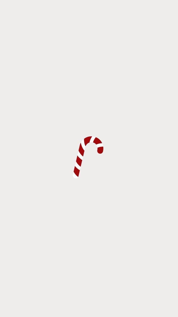 a red and white candy cane on a gray background