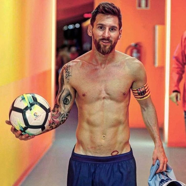 a man with tattoos holding a soccer ball