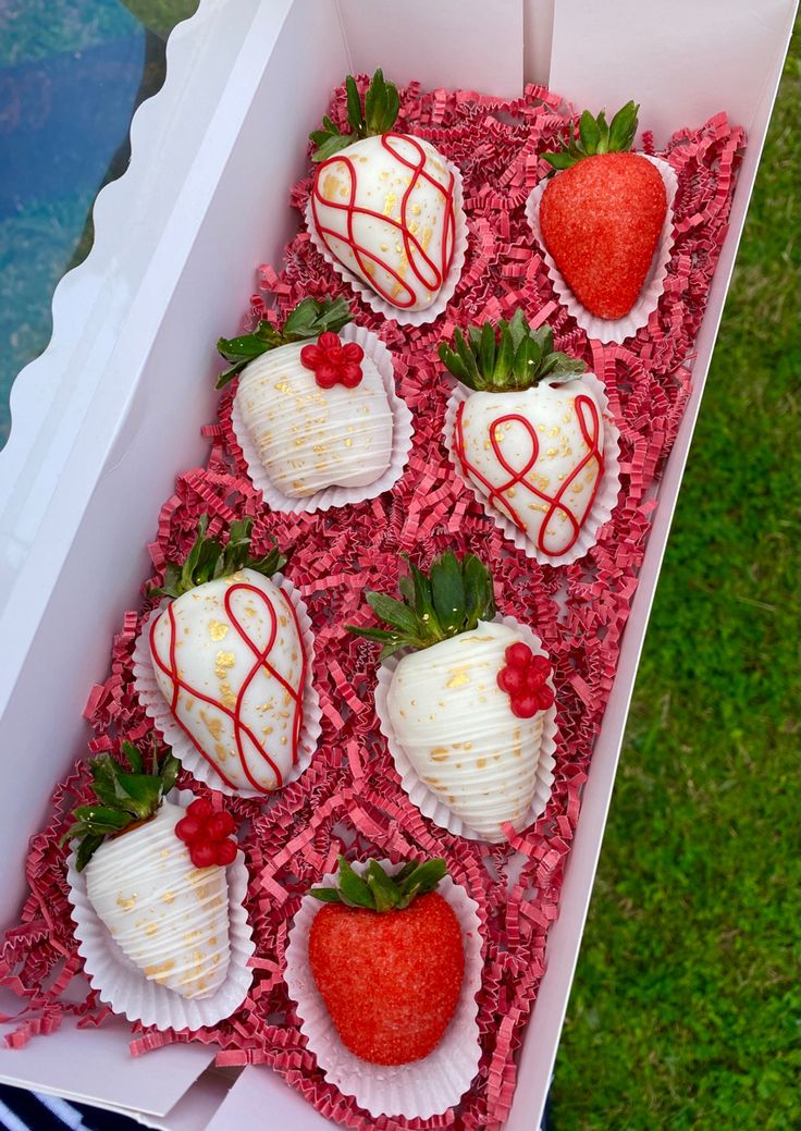 a box filled with chocolate covered strawberries on top of green grass