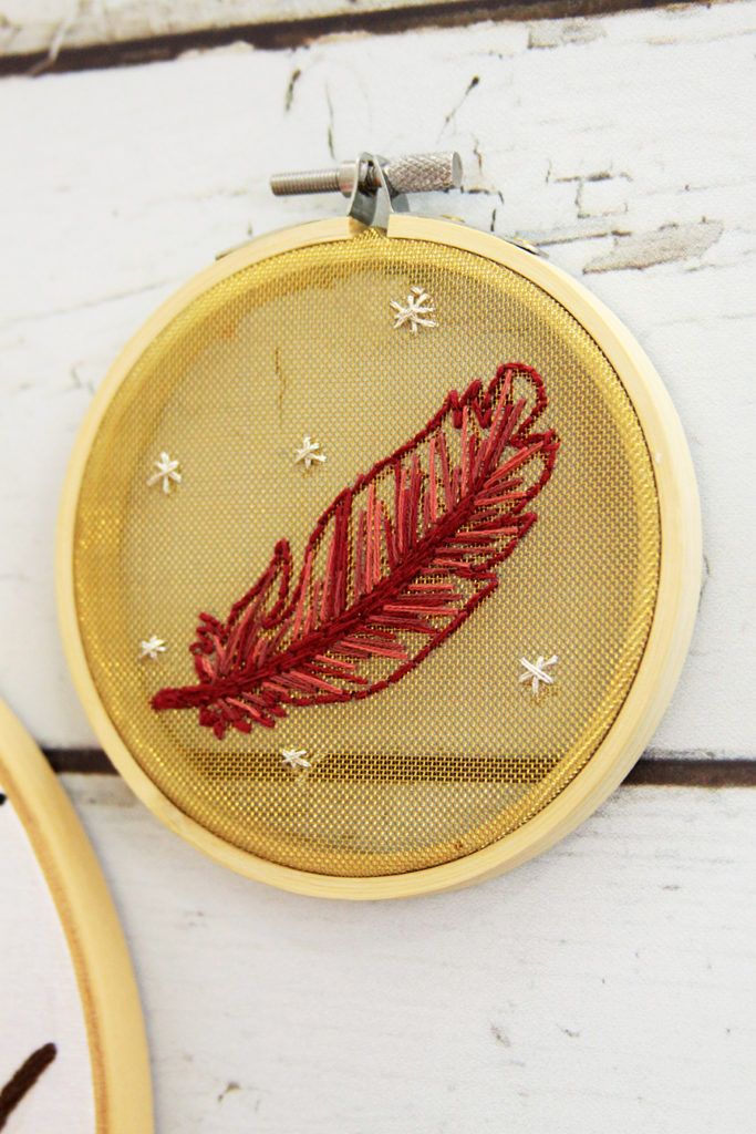 a red embroidered feather sitting on top of a wooden table