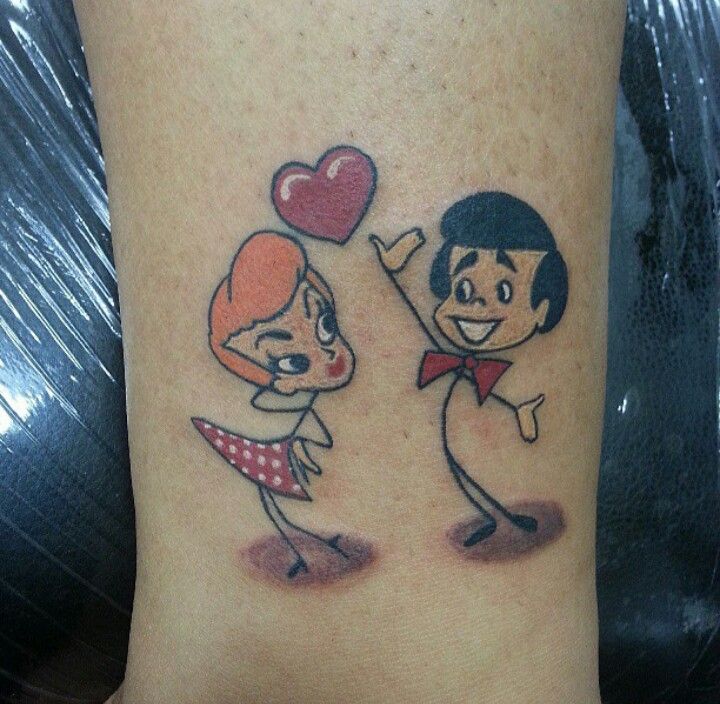 two cartoon tattoos on the leg of a person with a heart shaped balloon above them