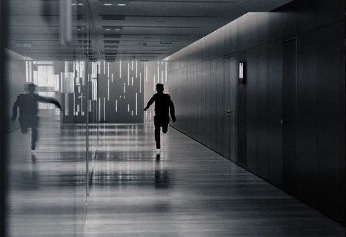 two people walking down a hallway in an office building