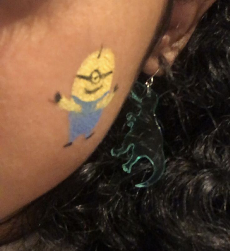 a person with a yellow and blue tattoo on their left side of her arm,