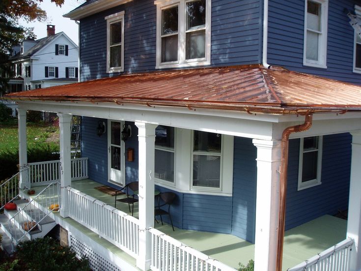 a blue and white house with a copper roof