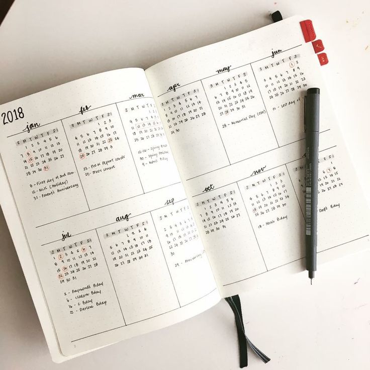 an open calendar book with a pen on it