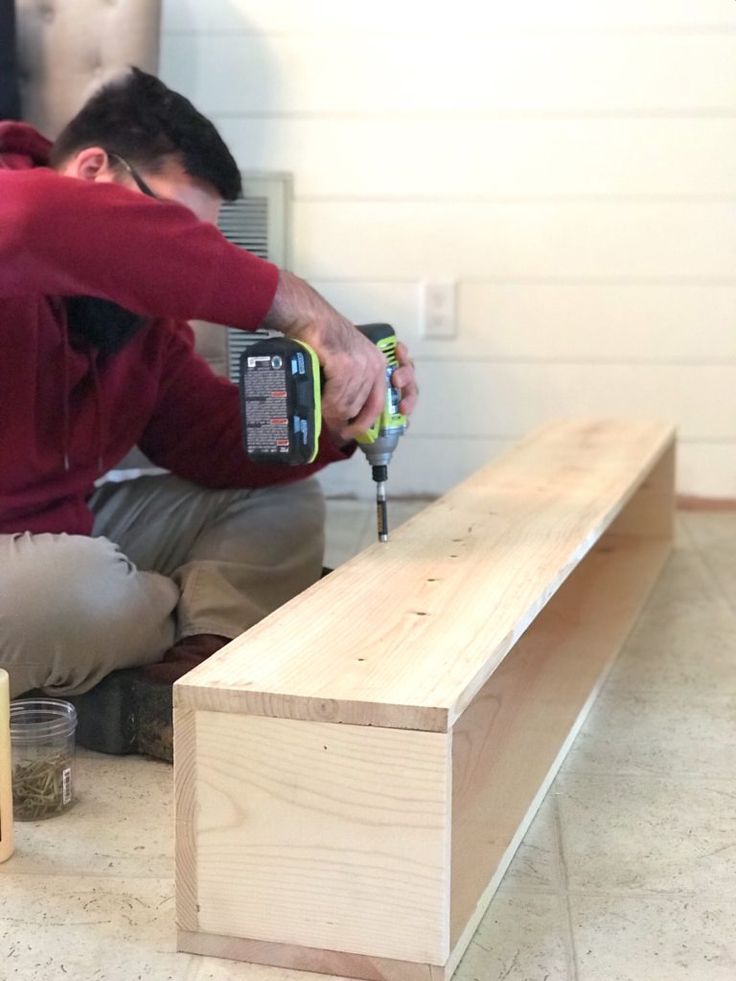 a man working on a bench with a drill and screwdriver in his hand