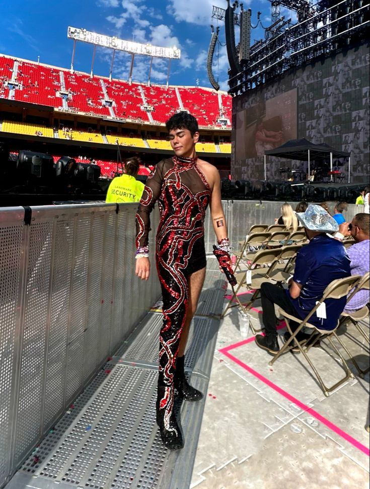 a man is walking down the runway at a stadium